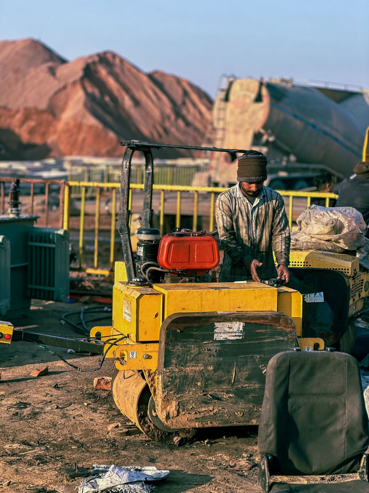 Construction worker operating a compaction roller on site