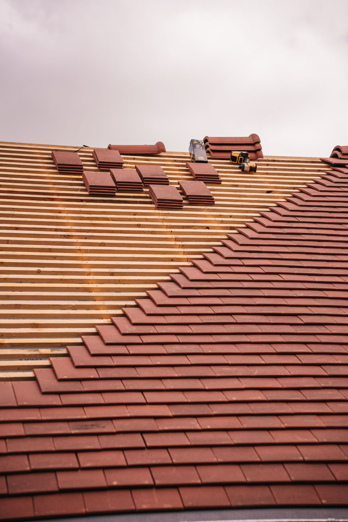 Roof tiles being laid in a stepped course during installation