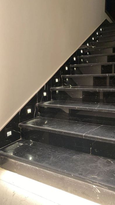 Black marble staircase with light strips embedded into the treads