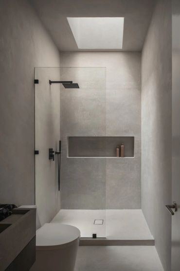 Minimalist matte-plaster shower with a skylight