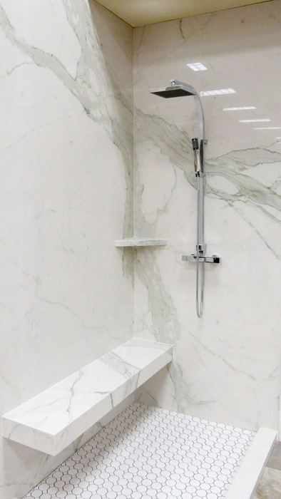 Grout-less shower floor system with a marble corner shelf